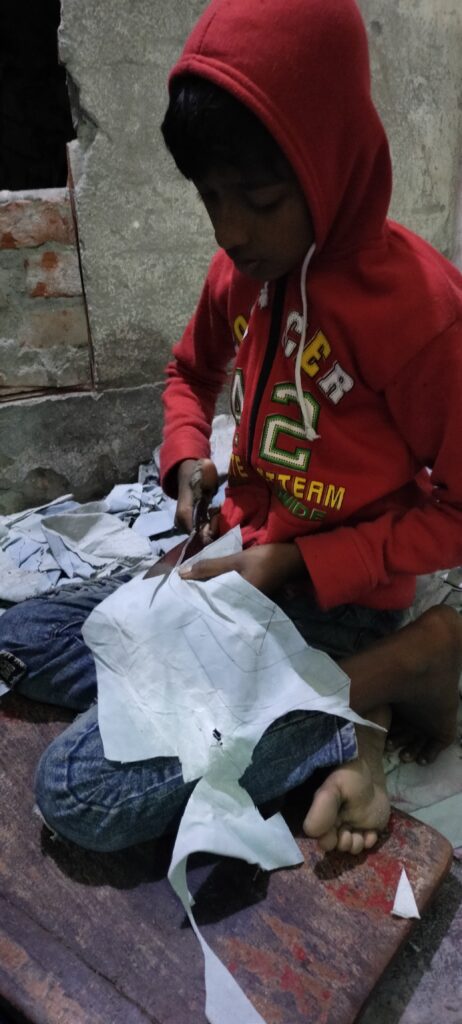 A child worker cutting leather