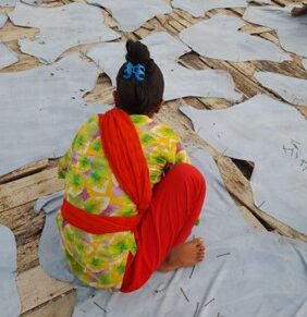 Jhilik pinning leather to the ground to dry