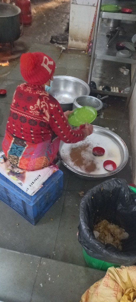 An older woman washing dishes